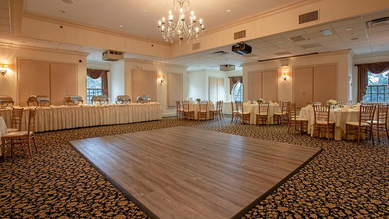Banquet room dance floor with view of set tables and chafing dishes