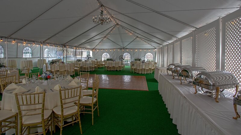 Outdoor banquet area with tables, dance floor and chaffing dish table